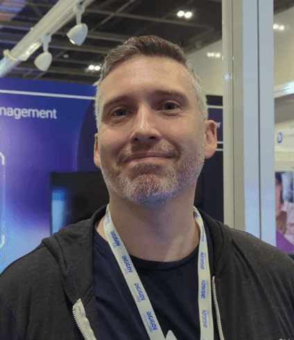 Richard Crampton, Senior ITSM Solution Engineer at Atlassian, wearing a black hoodie and a white lanyard at a fair.