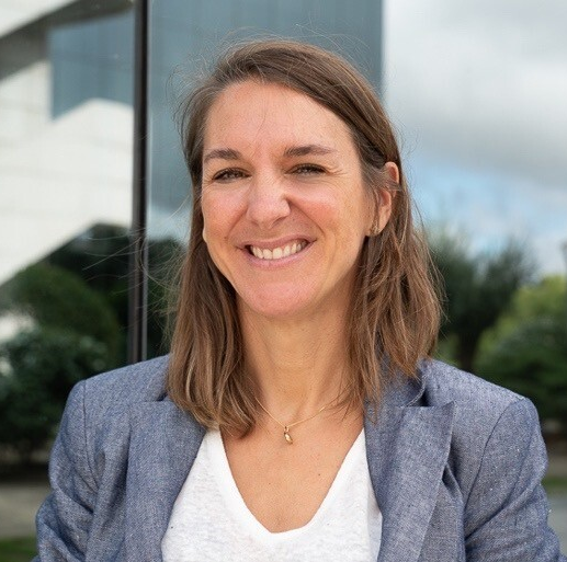 A smiling Gaëlle Laigo, Head of Agile & New Ways of Working Transformation from Orange Group wearing a white shirt with a blue blazer.