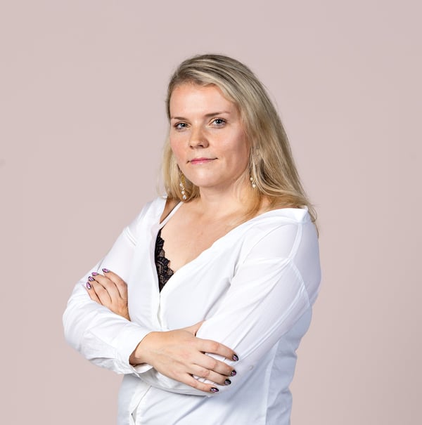 An image of Tiina Koivula, Head of Support Services at Accountor HR Solutions in a white shirt against a taupe background.
